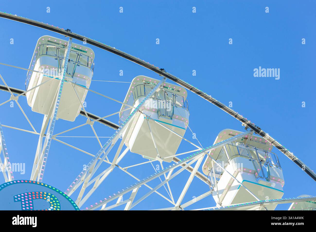 Ruota panoramica sullo sfondo blu del cielo. Attrazione presente nei parchi divertimenti. Foto Stock