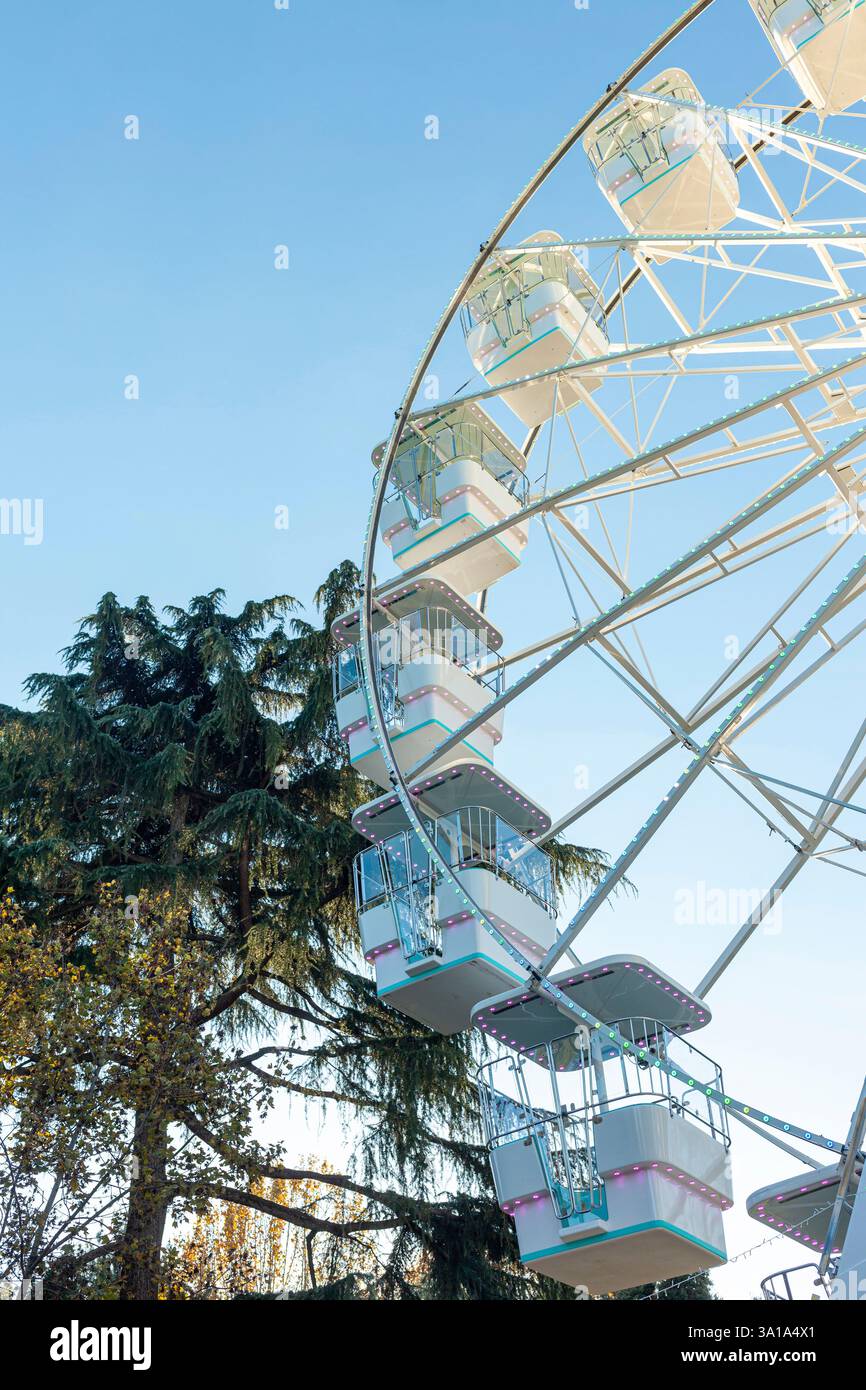 Ruota panoramica sullo sfondo blu del cielo. Attrazione presente nei parchi divertimenti. Foto Stock