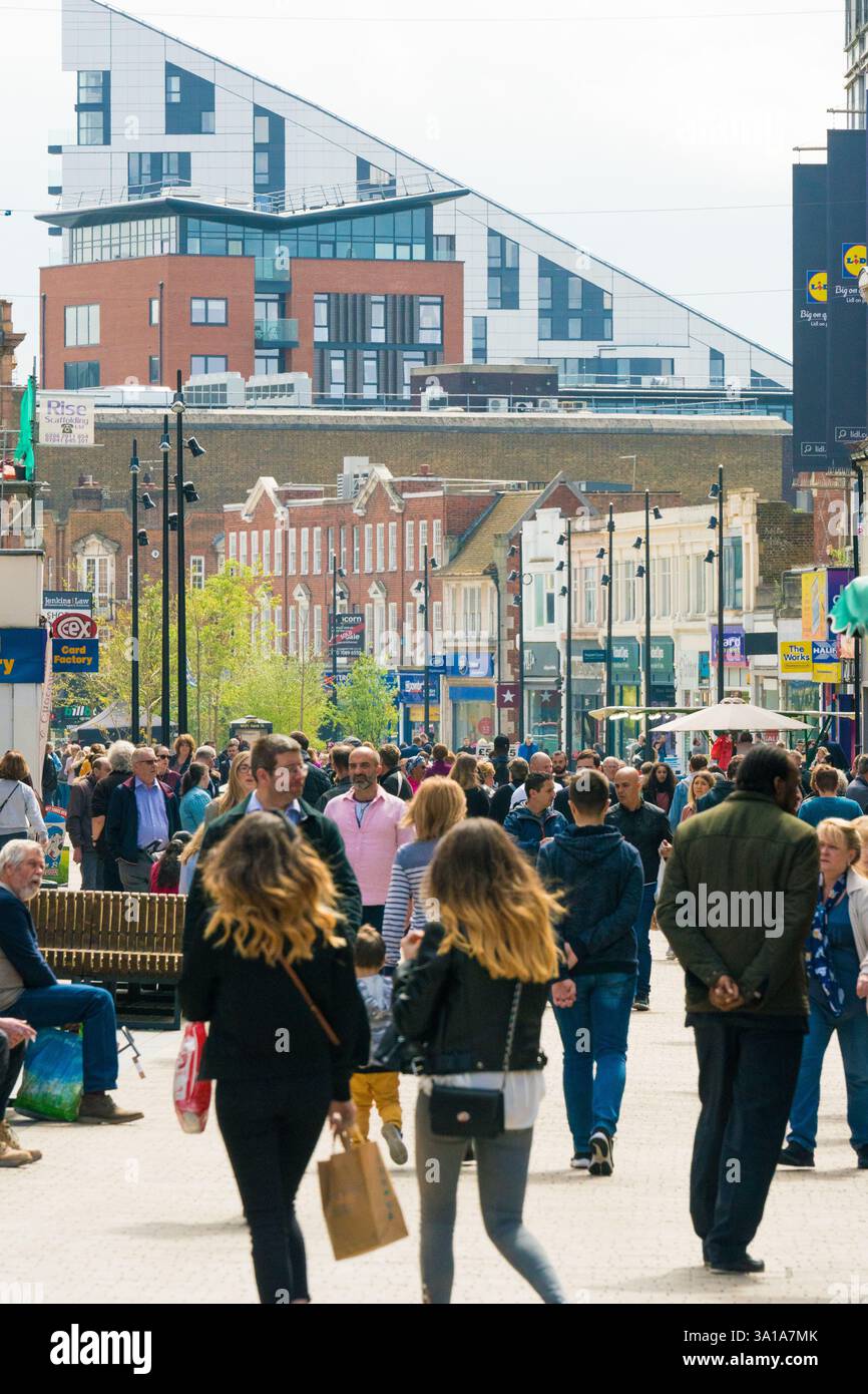 I pedoni attraversano la trafficata strada dello shopping nel centro della città di Bromley, Londra, in Inghilterra, passando davanti a edifici moderni e vecchi. Un mix di negozi e moder Foto Stock
