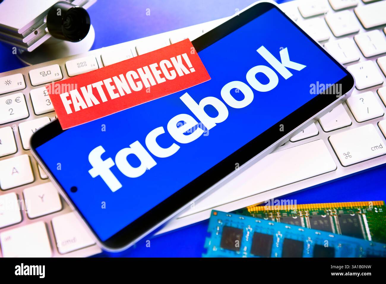 Smartphone con logo Facebook sulla tastiera del computer e nota con l'iscrizione Fact check, foto simbolica per la cancellazione del controllo dei fatti su Facebook Foto Stock