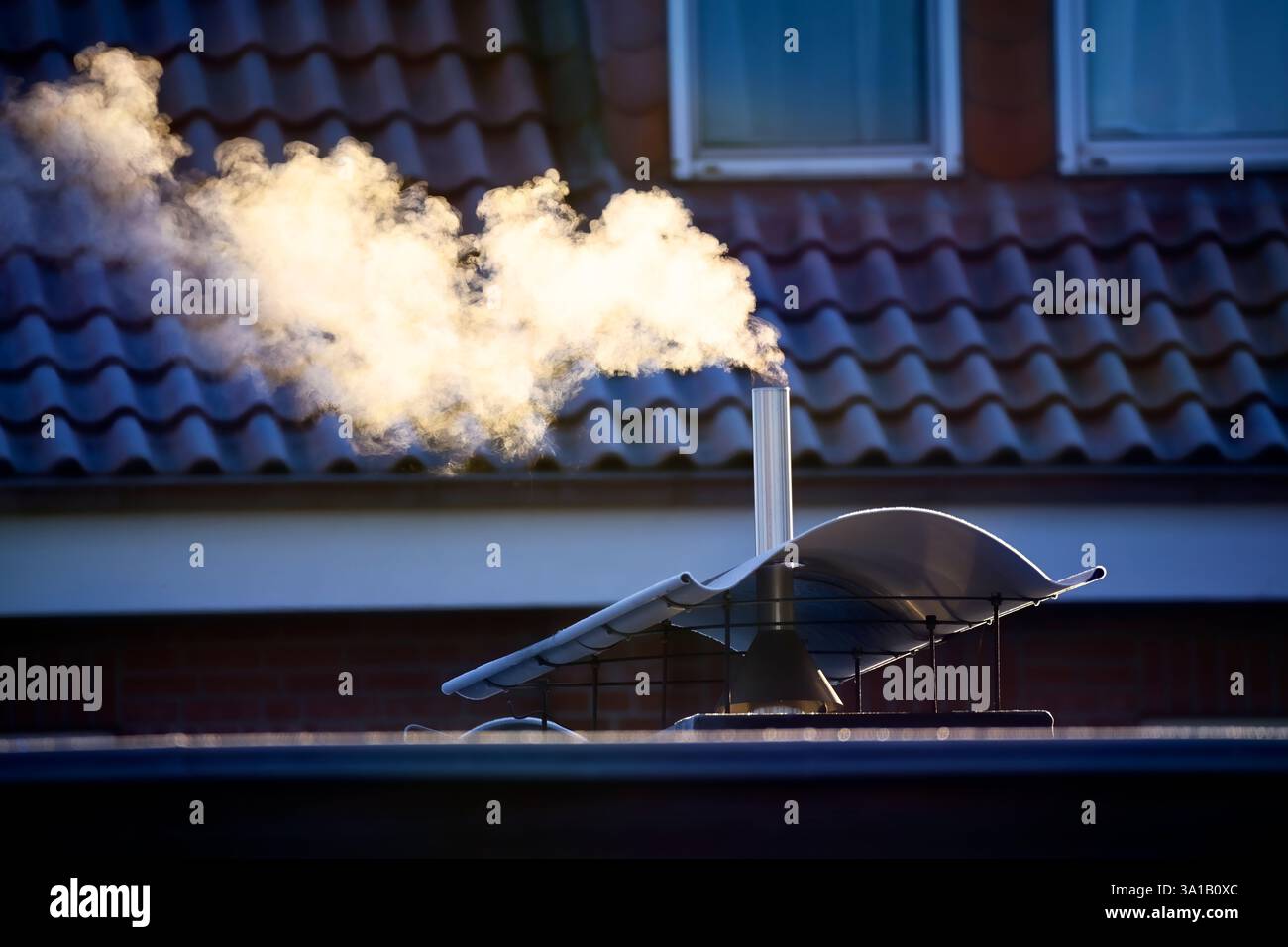 Il fumo del camino di una casa Foto Stock