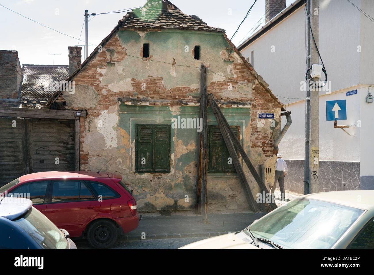 Edificio danneggiato, Str. Pielariilor, Romania. Un uomo passa davanti. Foto Stock