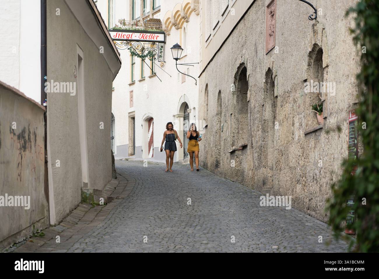Due donne camminano lungo un vicolo acciottolato Salisburgo, Austria Foto Stock