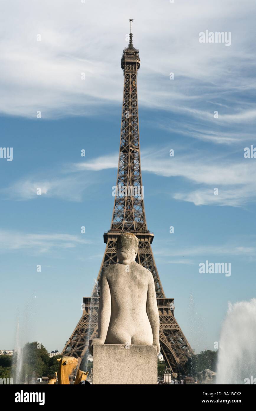 La statua di una donna, rivolta verso l'esterno, si trova in cima a una base di fontane, con la Torre Eiffel sullo sfondo, Parigi, Francia. Foto Stock