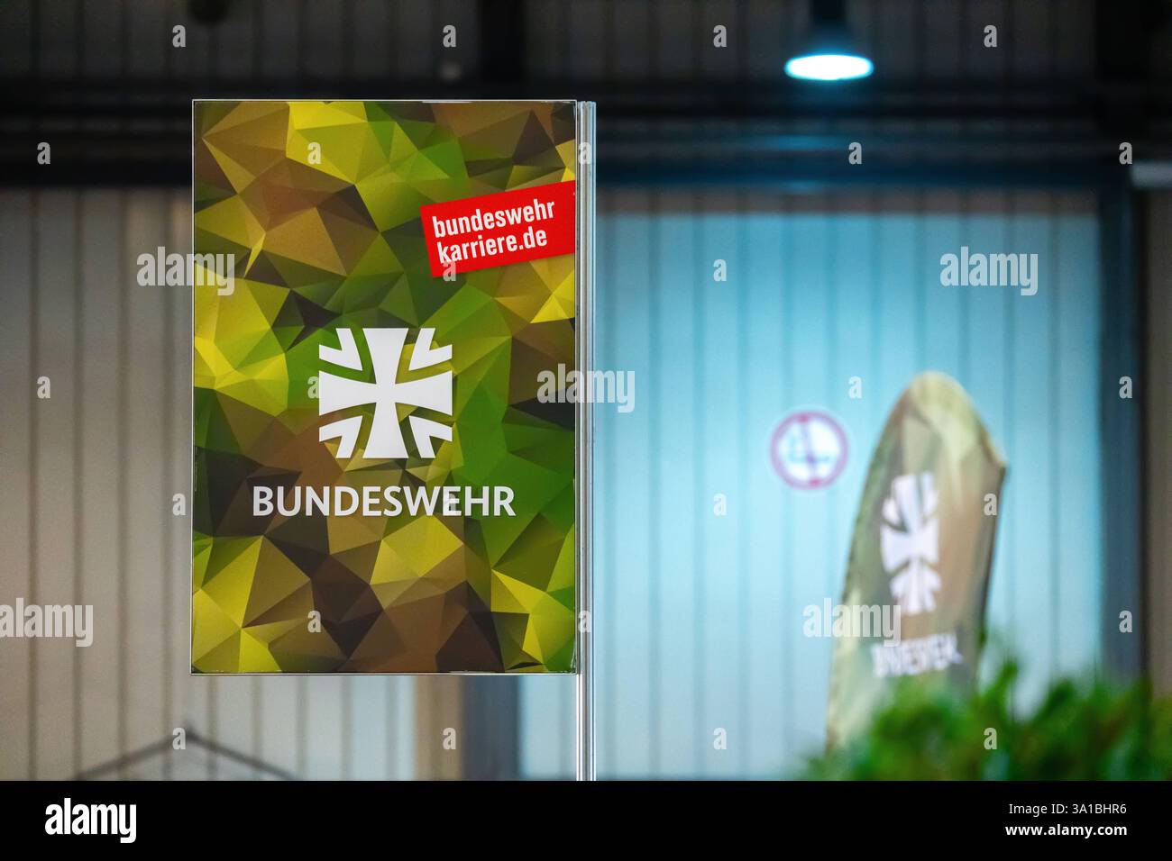 Augusta, Baviera, Germania - 7 marzo 2025: Manifesto di reclutamento della Bundeswehr con schema mimetico come parte di uno stand informativo. Alla fiera Afair di Augusta. *** Bundeswehr-Rekrutierungsplakat mit Tarnmuster-Design als Teil eines Infostands. Auf der Afair-Messe ad Augusta. Foto Stock