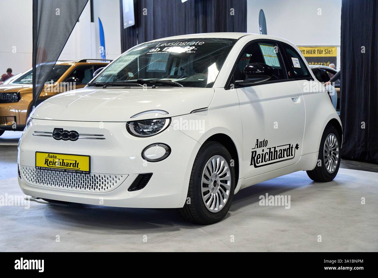 Augusta, Baviera, Germania - 7 marzo 2025: La fiera VOLT e-Mobility nell'ambito della fiera AFAIR di Augusta. Una Fiat 500 elettrica bianca si trova nella sala espositiva. La piccola auto con trazione elettrica è in mostra e presenta un tasso di leasing sul finestrino anteriore *** die VOLT e-Mobilitätsmesse im Rahmen der AFAIR Messe ad Augusta. Ein Weißer Fiat 500 Elektro steht in der Messehalle. Der Kleinwagen mit e-Antrieb wird ausgestellt und präsentiert eine Leasingrate im Frontfenster Foto Stock