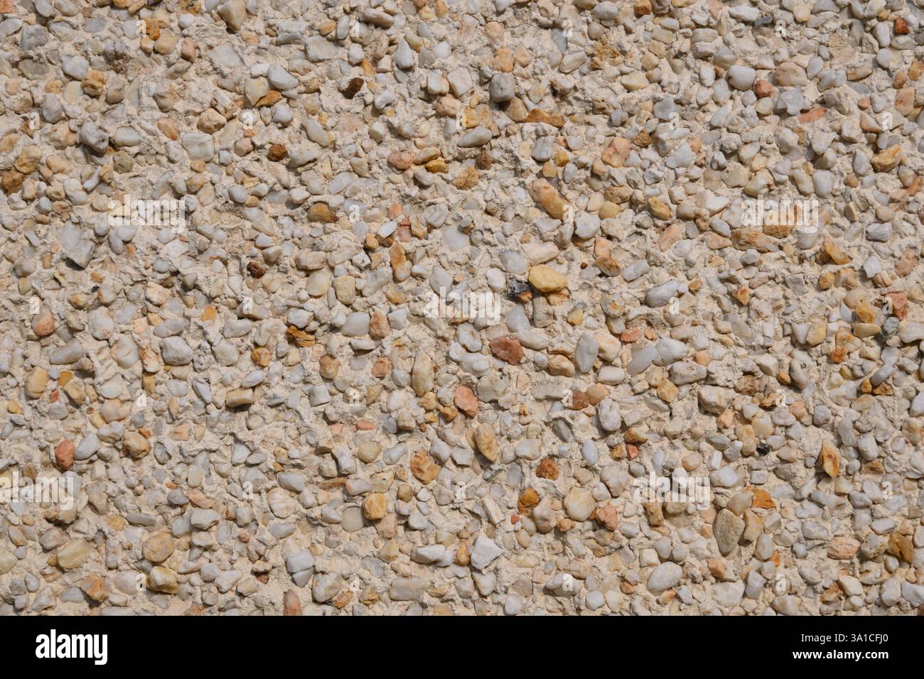 Un muro con una superficie in pietra bianca e marrone. La pietra è composta da piccole rocce e ciottoli Foto Stock