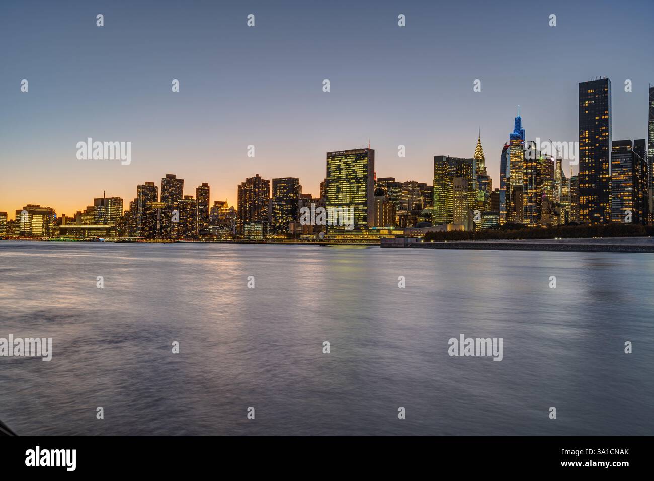 Lo skyline di Midtown Manhattan con il Chrysler Buidling e l'ONU-Building dopo il tramonto Foto Stock