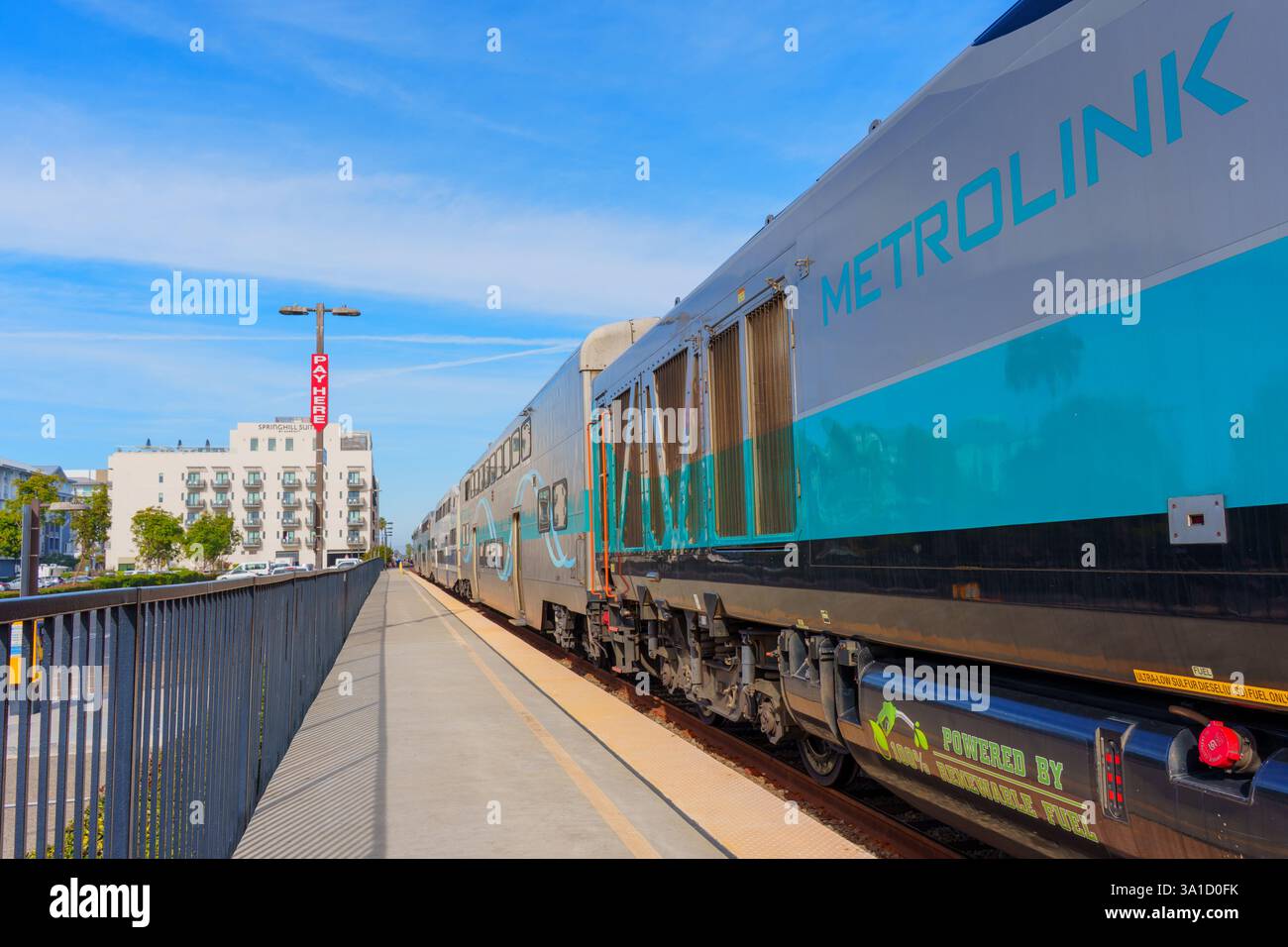 Oceanside, California - 26 dicembre 2024: Treno Metrolink alla stazione, con lo SpringHill Suites by Marriott visibile sullo sfondo, sotto una b Foto Stock