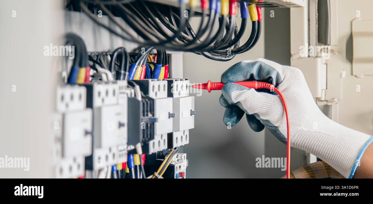 Gli ingegneri elettrici testano gli impianti elettrici e i cablaggi elettrici misurandoli con un multimetro. Foto Stock