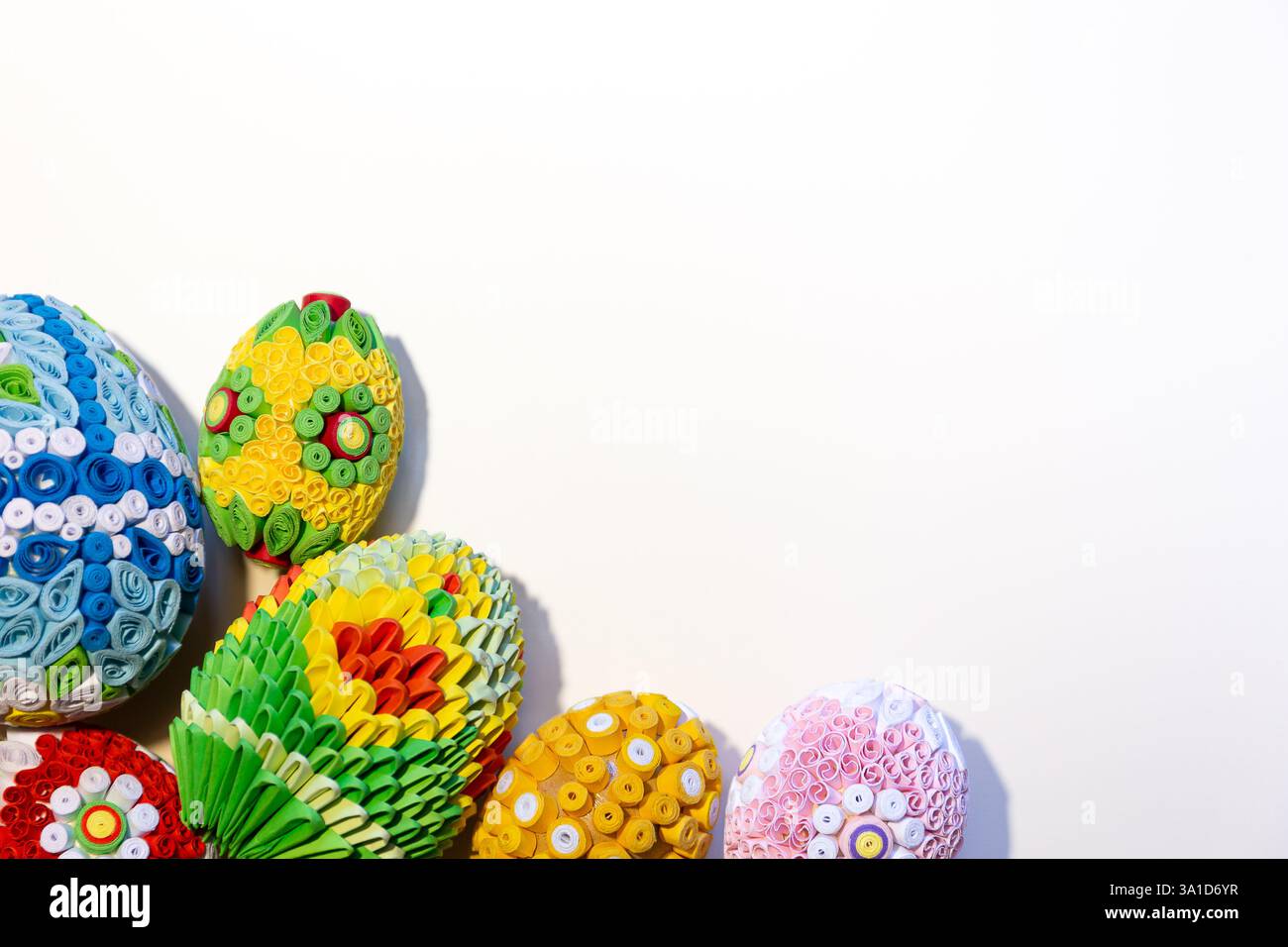 Sfondo pasquale bianco con uova di Pasqua colorate con ornamenti floreali e decorazioni origami nell'angolo, copia spazio. Foto Stock