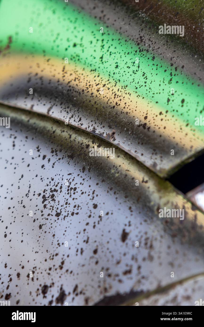 Specchio invecchiato con crepe e punti degradati in cui il supporto riflettente è scomparso, distorcendo le forme nelle tonalità verde e giallo Foto Stock