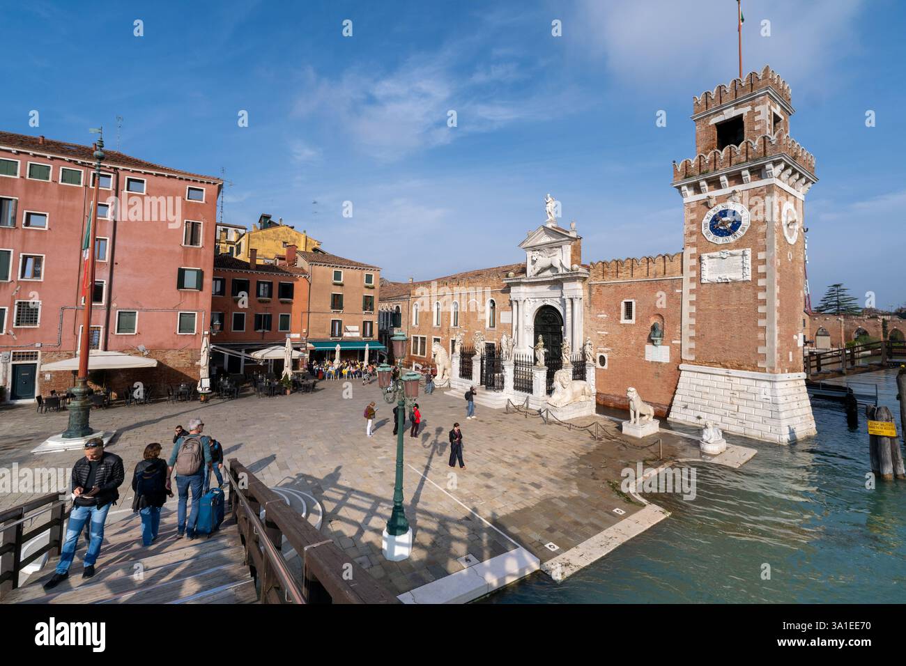 Venezia, Italia - 12 ottobre 2024: L'ingresso storico dell'Arsenale di Venezia con la sua porta in marmo ornato, la torre dell'orologio e il ponte in legno Foto Stock