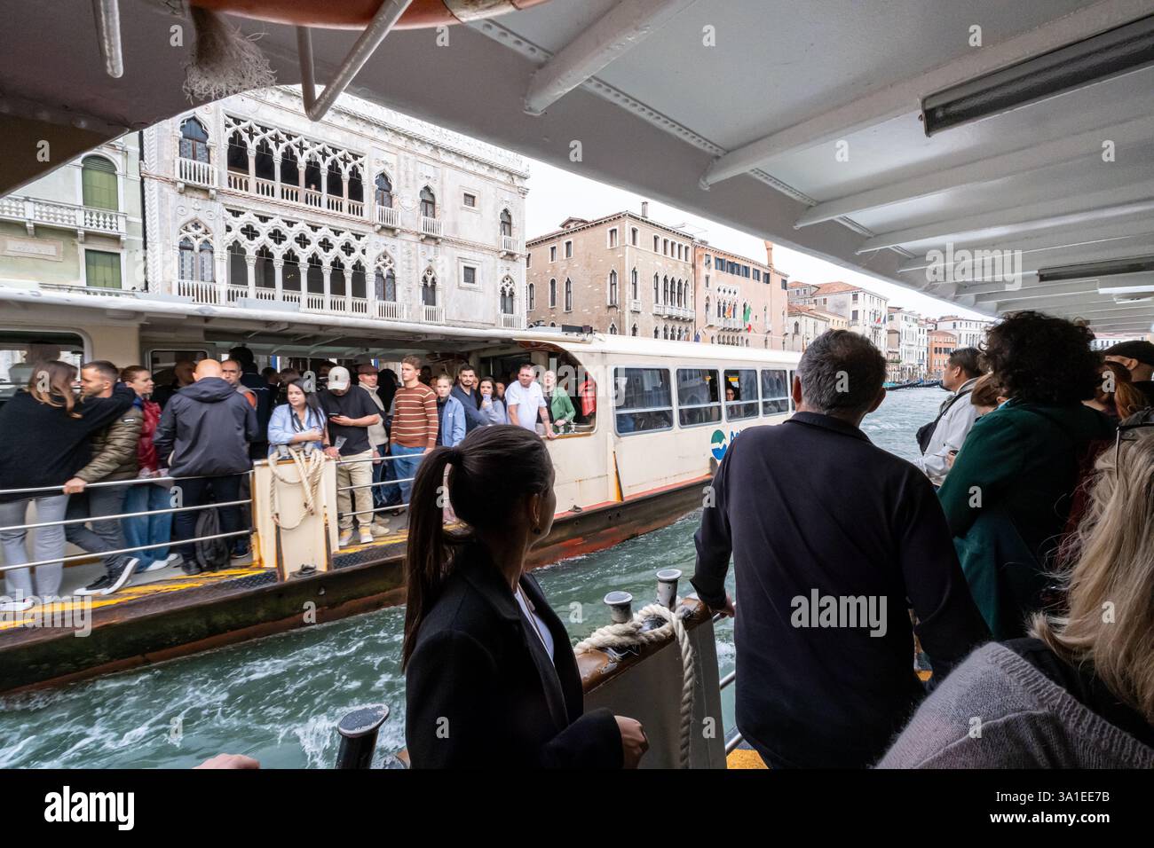 Venezia, Italia - 12 ottobre 2024: I passeggeri si trovano su un vaporetto affollato che naviga sul Canal grande Foto Stock