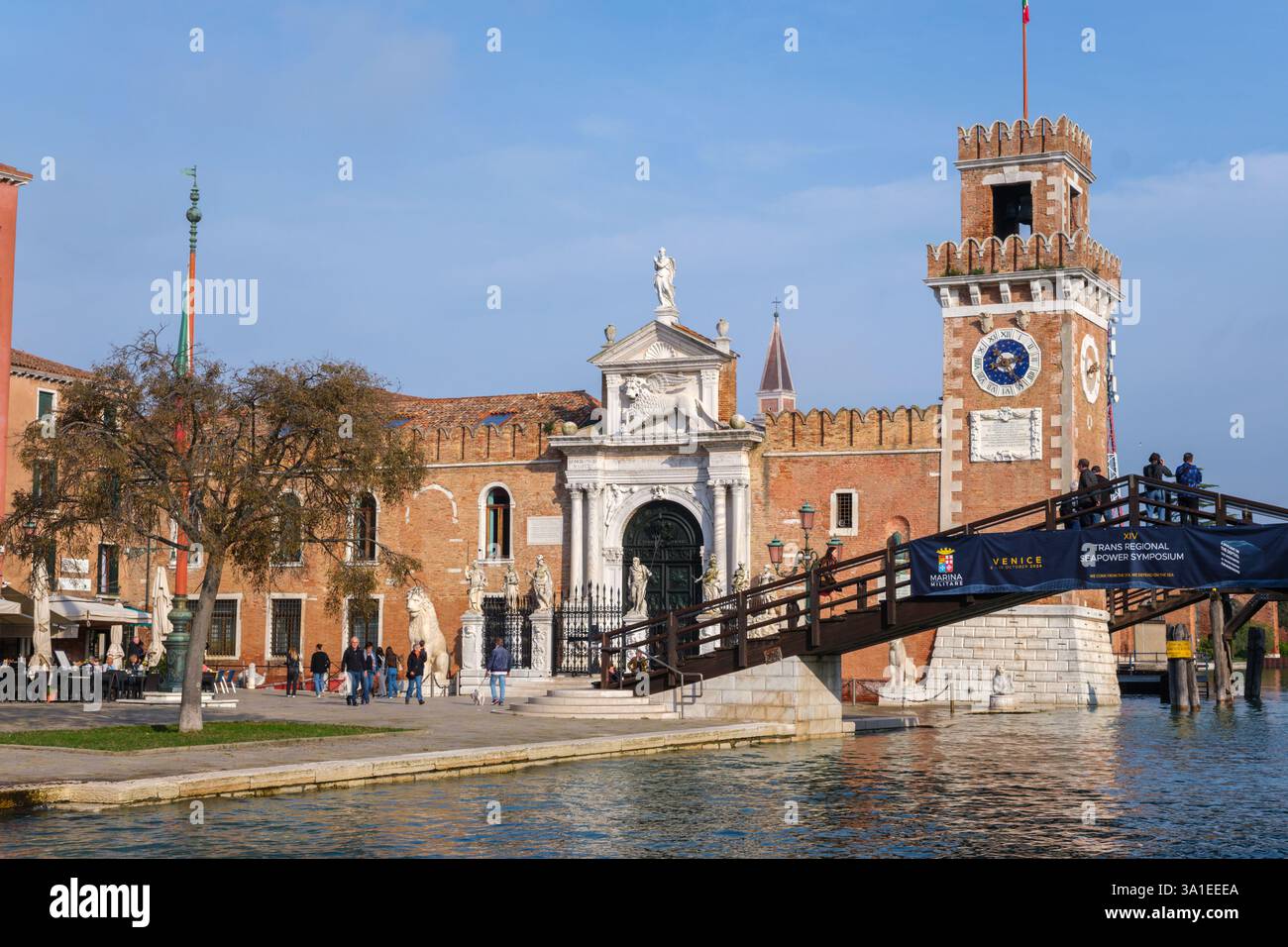 Venezia, Italia - 12 ottobre 2024: L'ingresso storico dell'Arsenale di Venezia con la sua porta in marmo ornato, la torre dell'orologio e il ponte in legno Foto Stock
