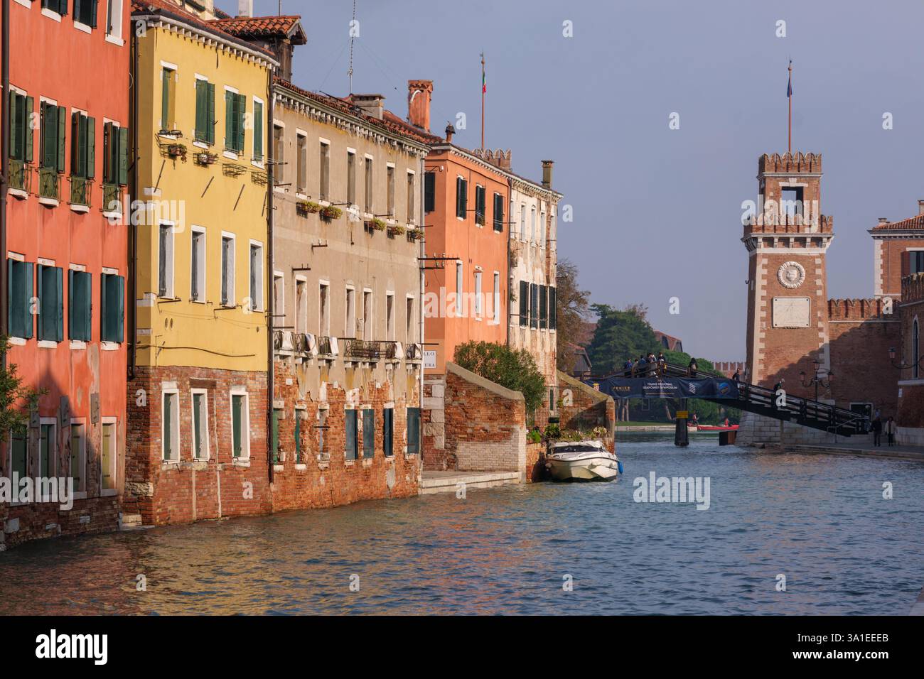 Venezia, Italia - 12 ottobre 2024: Vista panoramica del canale dell'Arsenale veneziano con edifici storici colorati che si riflettono nell'acqua. Una torre dell'orologio e. Foto Stock