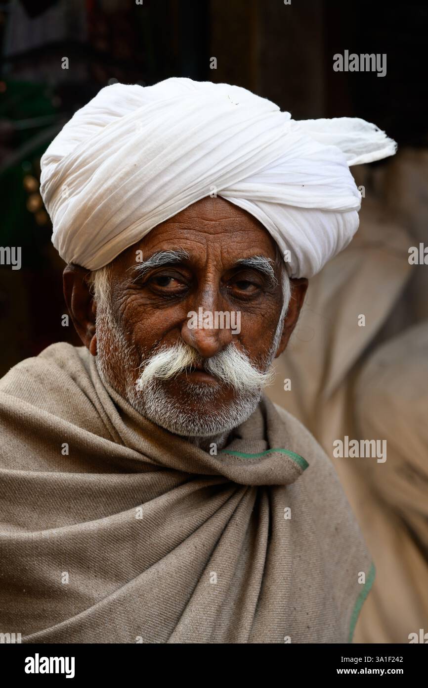 Jaisalmer, Rajasthan, India - 12 febbraio 2025: Uomo Rajasthani che indossa un turbante Safa bianco con baffi grigi e abito tradizionale grigio Foto Stock