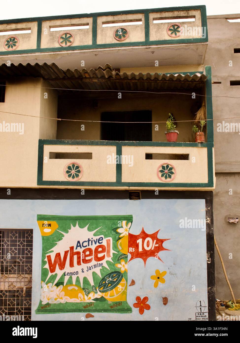 Facciata della casa a Bakraur-Sujata, vicino a Bodh Gaya, con una pubblicità di detersivo per ruote attive dipinta a mano. Foto Stock