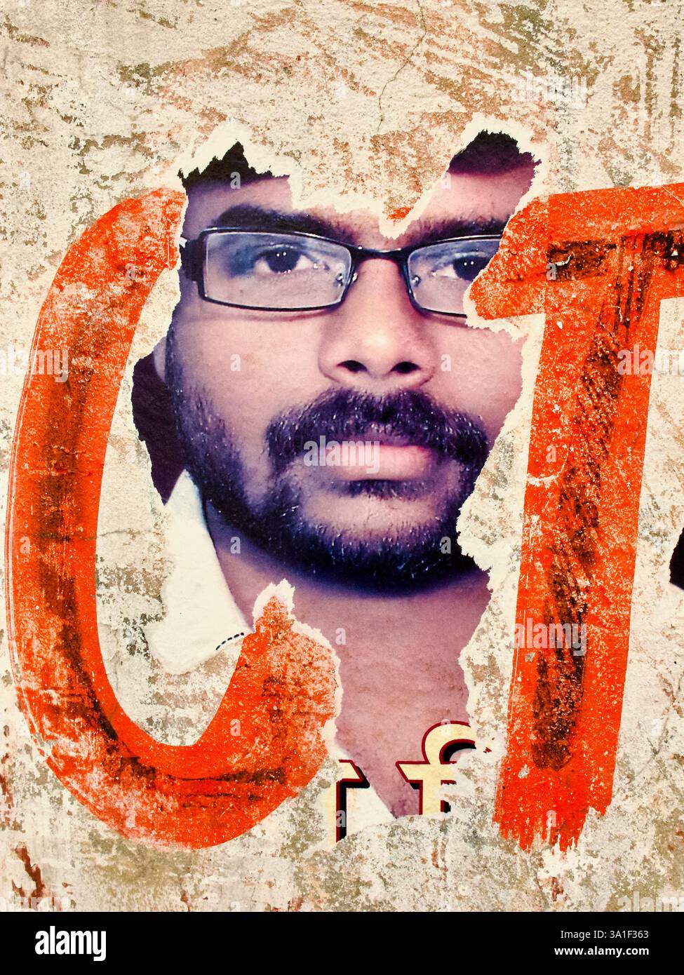 Strati di poster strappati su una parete intemprata a Varanasi rivelano un ritratto frammentato che riflette l'ambiente urbano in continua evoluzione e la narrazione visiva. Foto Stock