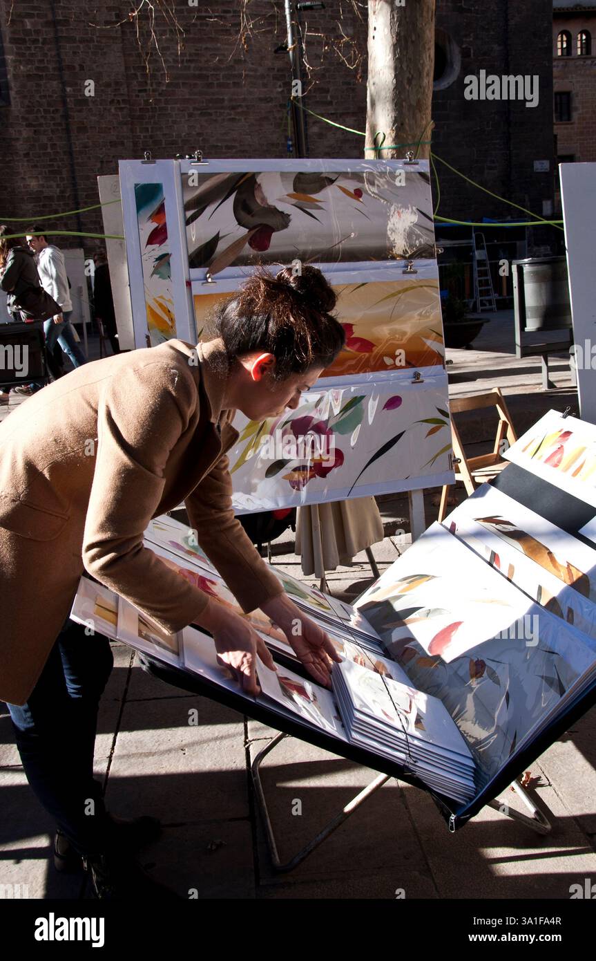 Artista donna con le sue opere d'arte in Plaza del Pino Painters Art Exhibition, Barcellona, Ciutat Vella, Spagna Foto Stock