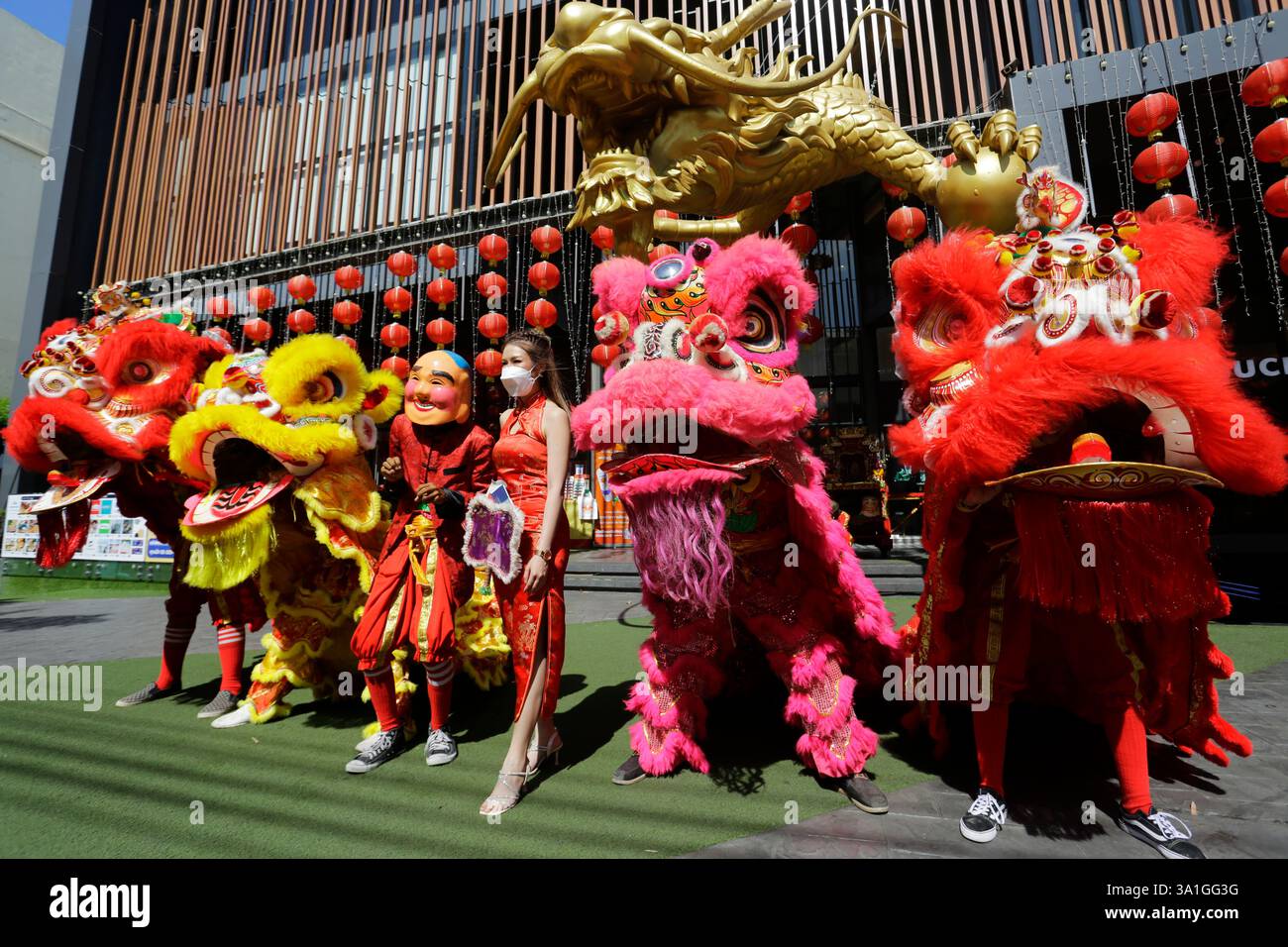 Bangkok, Tailandia - 21 gennaio 2023: Ballerini che si esibiscono nella danza del leone per una foto con una donna che celebra il Capodanno lunare cinese. Foto Stock