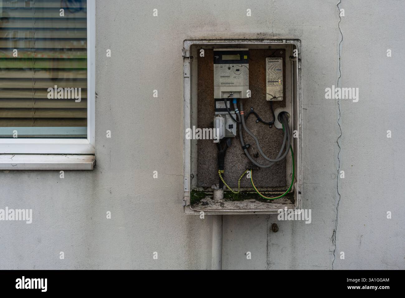 Scatola del contatore elettrico aperta montata su una facciata a parete esterna di una casa nel Regno Unito, Inghilterra, Regno Unito Foto Stock