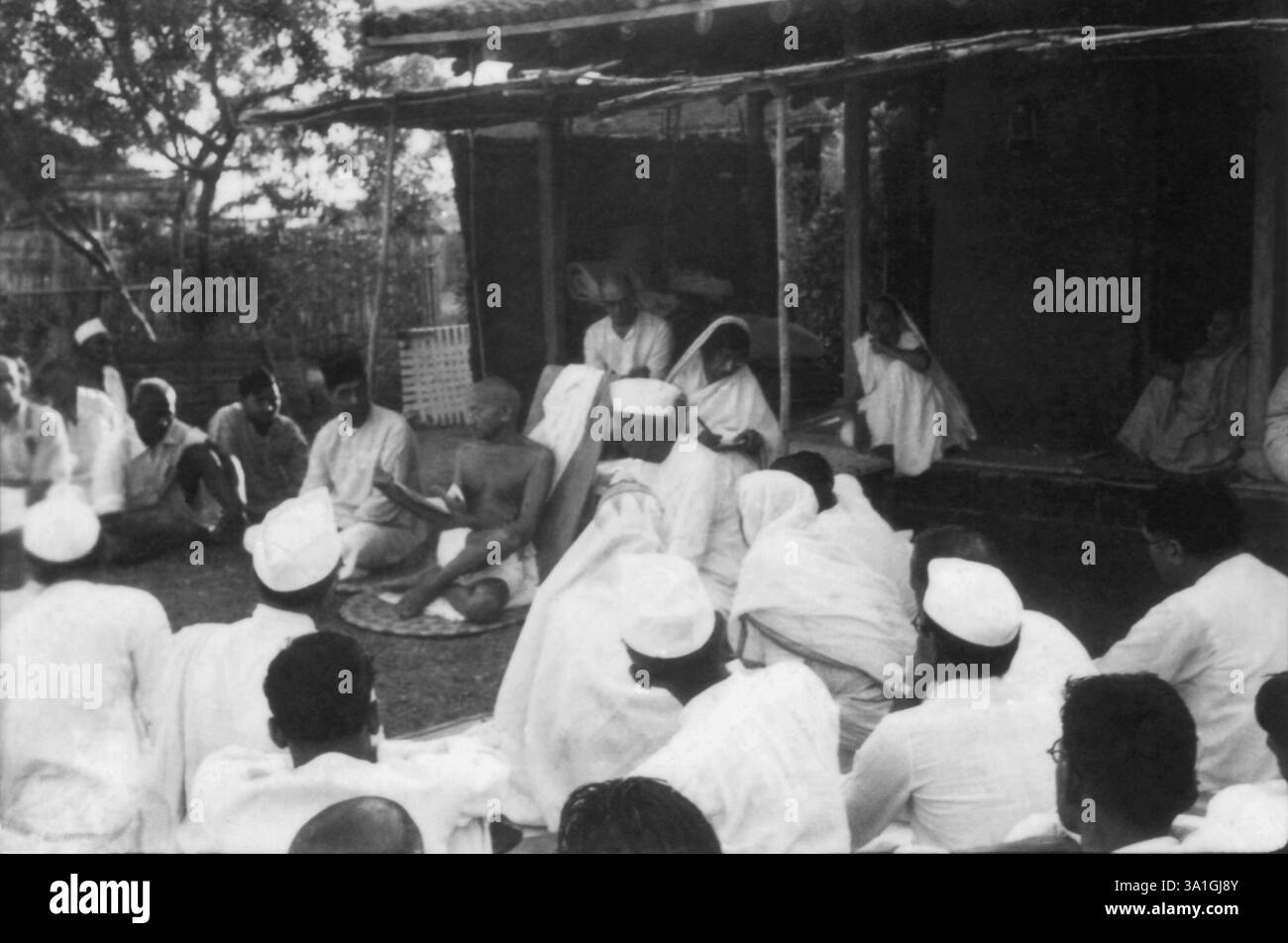 Mahatma Gandhi che parla a un gruppo di persone Sevagram Ashram, 1939 Thakkar Bapa, Mahadev Desai, Rajkumari Amrit Kaur, Kasturba Gandhi, India NO MR Foto Stock