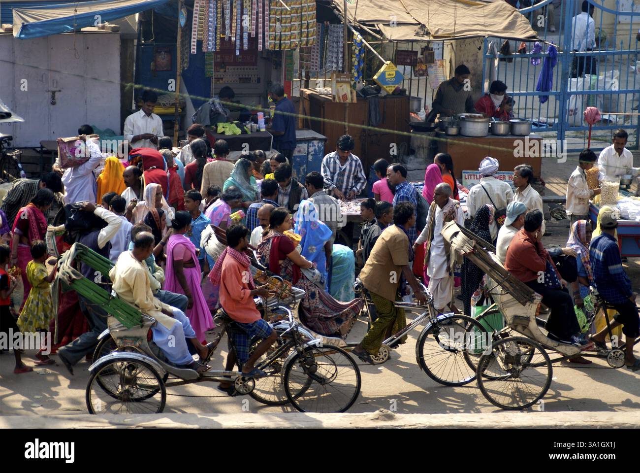 Persone che passano accanto alle bancarelle lungo la strada in risciò, Varanasi, Uttar Pradesh, India, Asia Foto Stock