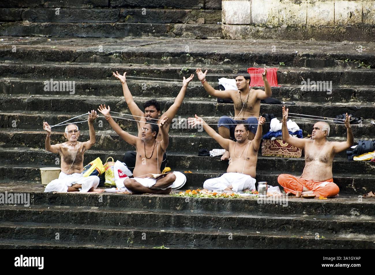 Janoi (Sacro filo) rituale mutevole dei bramini indù su una noce di cocco il giorno di Purnima (Shravanik Upakarma) a Banganga Tank, Walkeshwar, Mumbai Bombay, Foto Stock