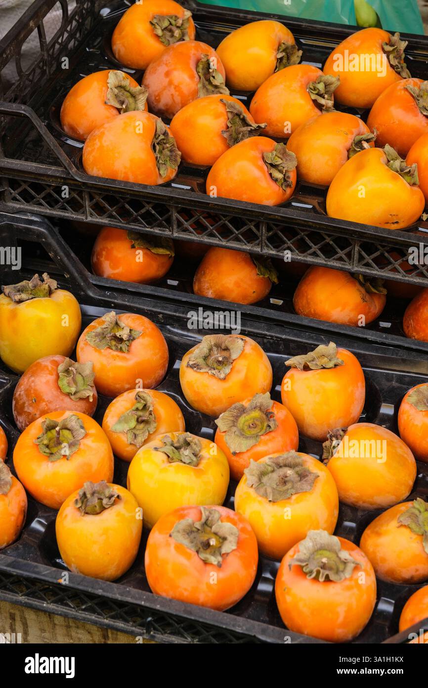 Gaziantep, Turchia, Turkiye. Persimmons freschi in vendita presso il negozio sul marciapiede. Foto Stock