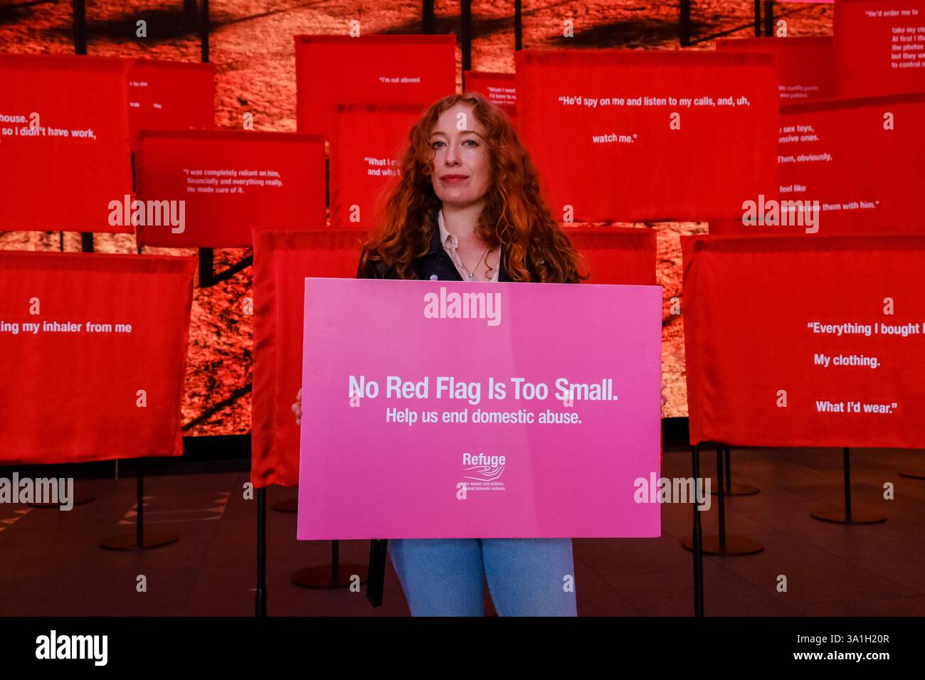 Londra, Regno Unito. 8 marzo 2025. L'attore Victoria Yeates sostiene la campagna "No Red Flag is too small" Refuge. L'installazione immersiva di un giorno presso The Outernet, da parte della più grande organizzazione di abusi domestici del Regno Unito, è stata progettata per aiutare a identificare i segnali di allarme degli abusi e a sensibilizzare l'opinione pubblica. L'installazione di 100 bandiere rosse e bandiere digitali, ciascuna con una citazione stampata di un sopravvissuto agli abusi domestici, crea un display di impatto visivo. Credito: Fotografia dell'undicesima ora/Alamy Live News Foto Stock