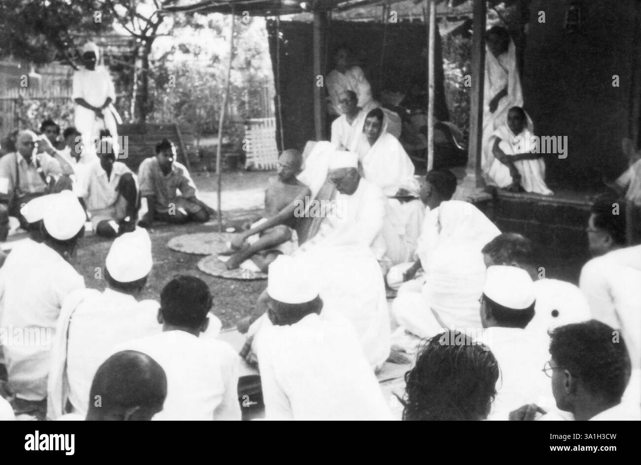 Mahatma Gandhi che parla a un gruppo di persone Sevagram Ashram, 1939 Thakkar Bapa, Mahadev Desai, Rajkumari Amrit Kaur, Kasturba Gandhi, India NO MR Foto Stock