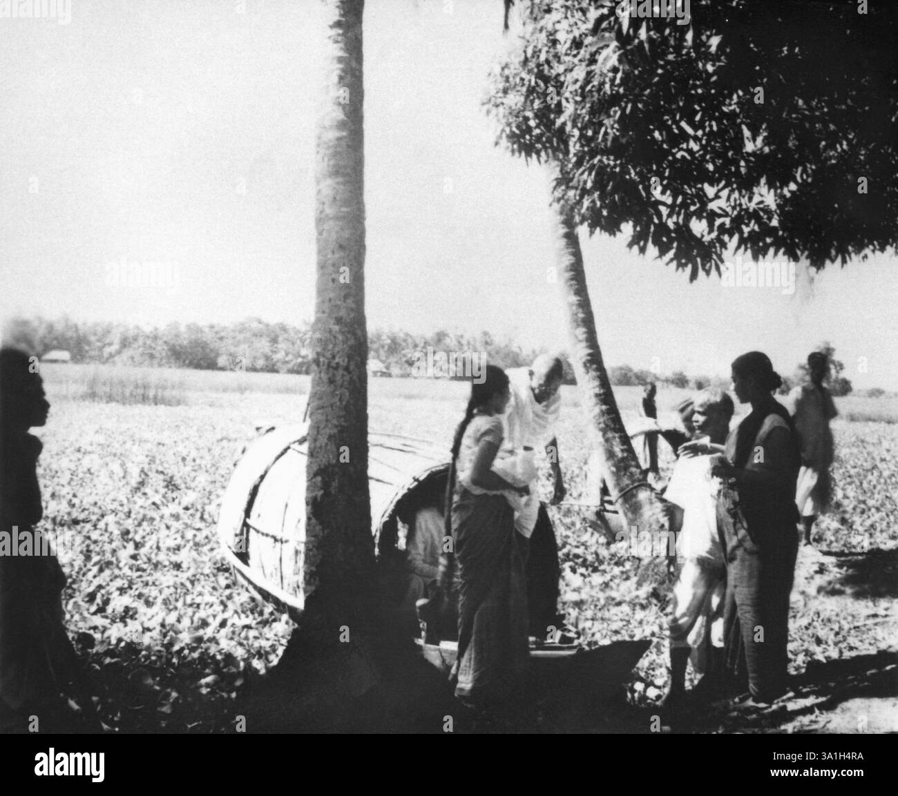 Mahatma Gandhi, accompagnato da Abha Gandhi che lascia una barca durante la sua visita nella zona colpita dalla rivolta di Noakhali nel Bengala Orientale Foto Stock