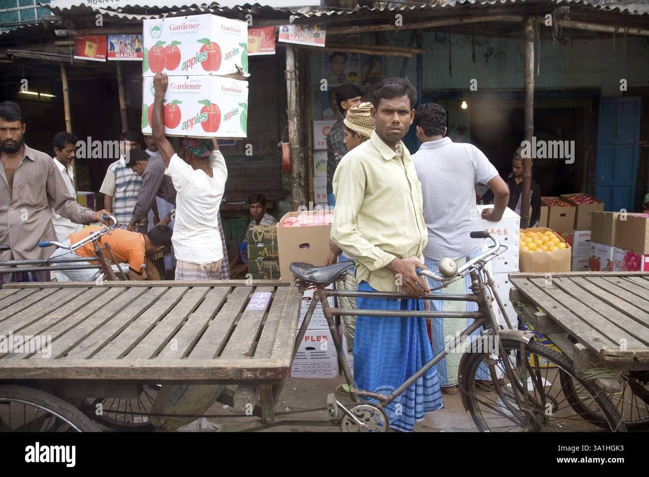 Uomo musulmano che indossa lungi e camicia con risciò per trasportare bagagli, Dacca, Bangladesh, Asia Foto Stock