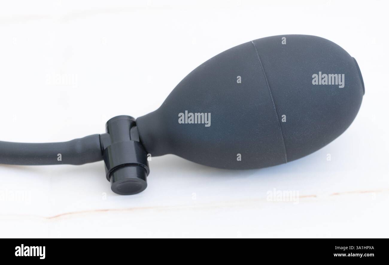 Un soffiatore d'aria nero opaco con una maniglia gonfiabile sul lato, appoggiato su una superficie bianca Foto Stock