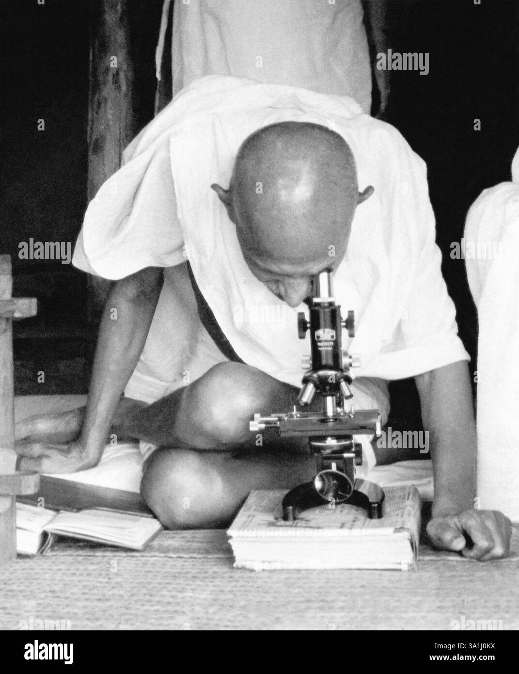 Mahatma Gandhi e assistente ospedaliero Shankaranji al microscopio osservando i germi della lebbra a Sevagram Ashram, c 1942 NO MR Foto Stock