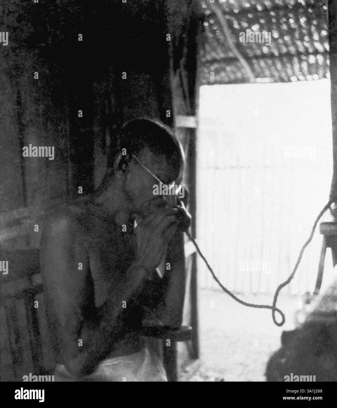 Mahatma Gandhi telefonando nella capanna dell'ufficio a Sevagram Ashram, 1940 NA MR Foto Stock