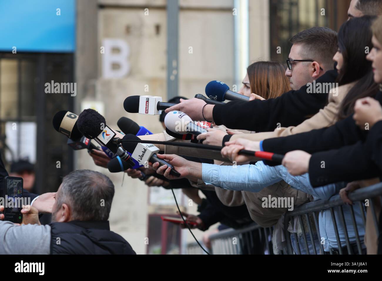 Bucarest, Romania - 7 marzo 2025: I rappresentanti dei media tengono i microfoni verso un politico. Foto Stock
