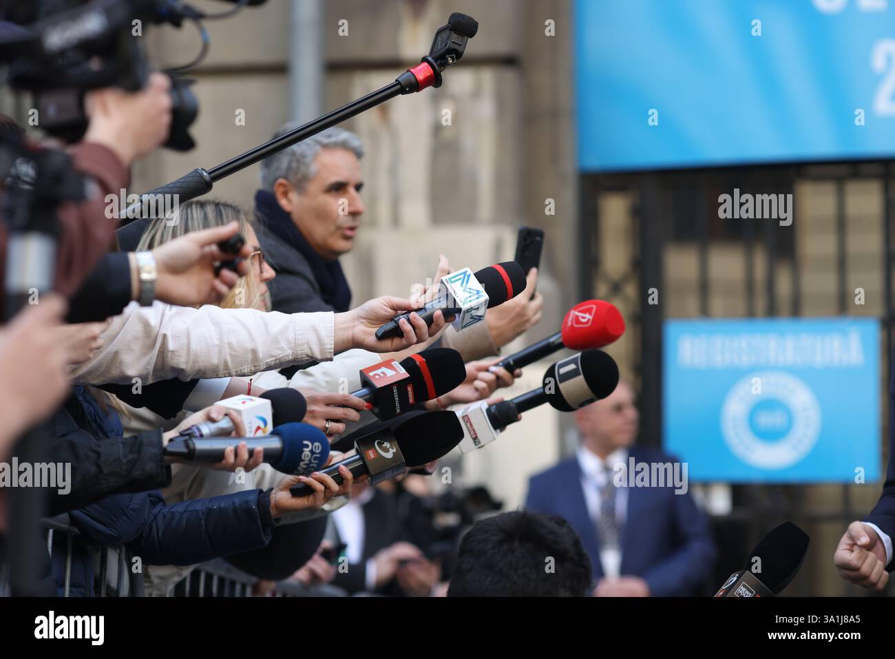 Bucarest, Romania - 7 marzo 2025: I rappresentanti dei media tengono i microfoni verso un politico. Foto Stock