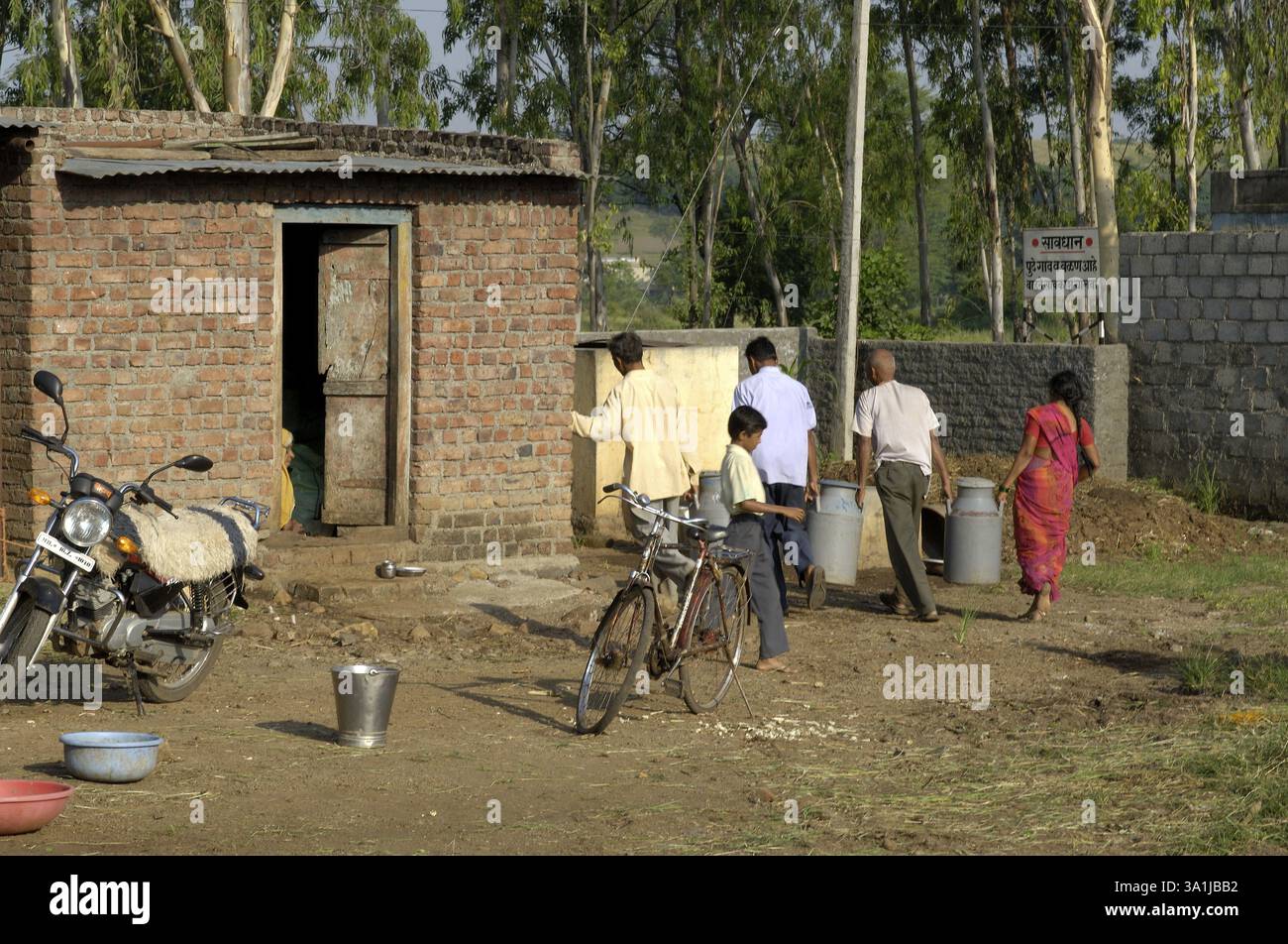 Lattine di latte trasportate verso il furgone a Ralegaon Siddhi, vicino a Pune, Maharashtra, India, Asia Foto Stock