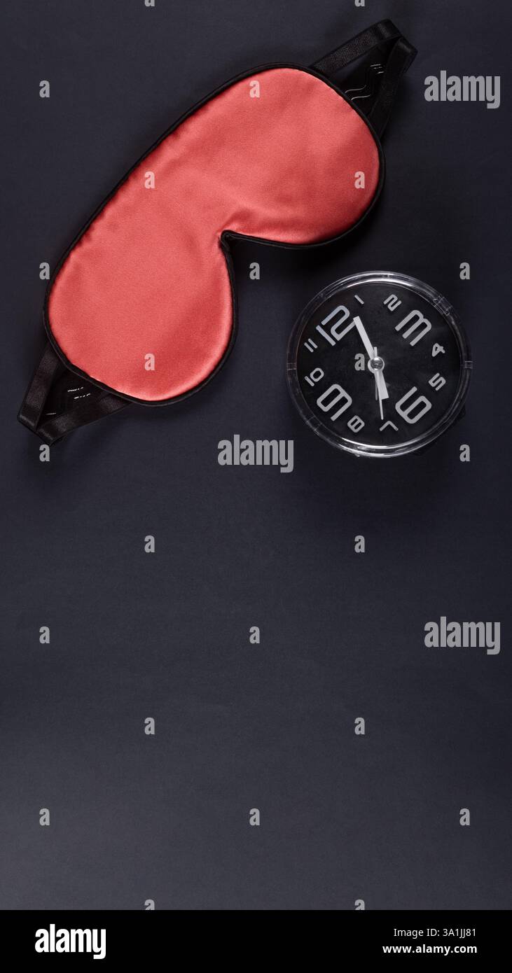 Maschera dormiente rossa e sveglia isolata su sfondo grigio scuro. Concetto World Sleep Day Foto Stock