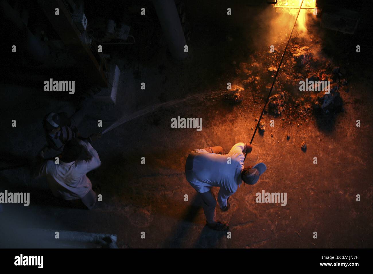 Lavoratori che mettono il carbone nello streamer per gestire l'alimentazione nella fabbrica di zucchero di Sangli, Maharashtra, India, Asia Foto Stock