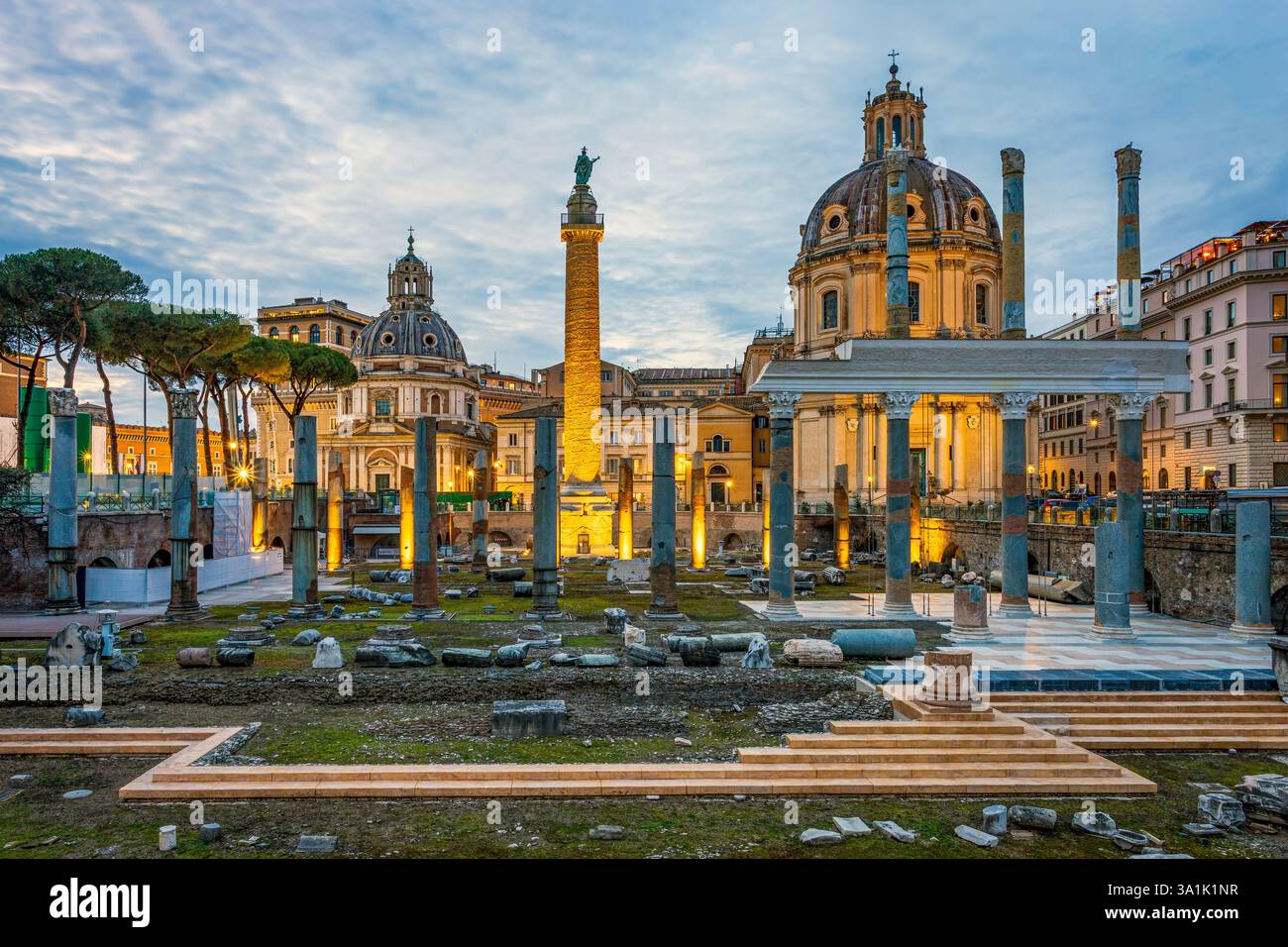 Foro e colonna dell'imperatore Traiano all'ora blu serale. Sullo sfondo si erge la chiesa illuminata di Santa Maria di Loreto. Foto scattata il Foto Stock