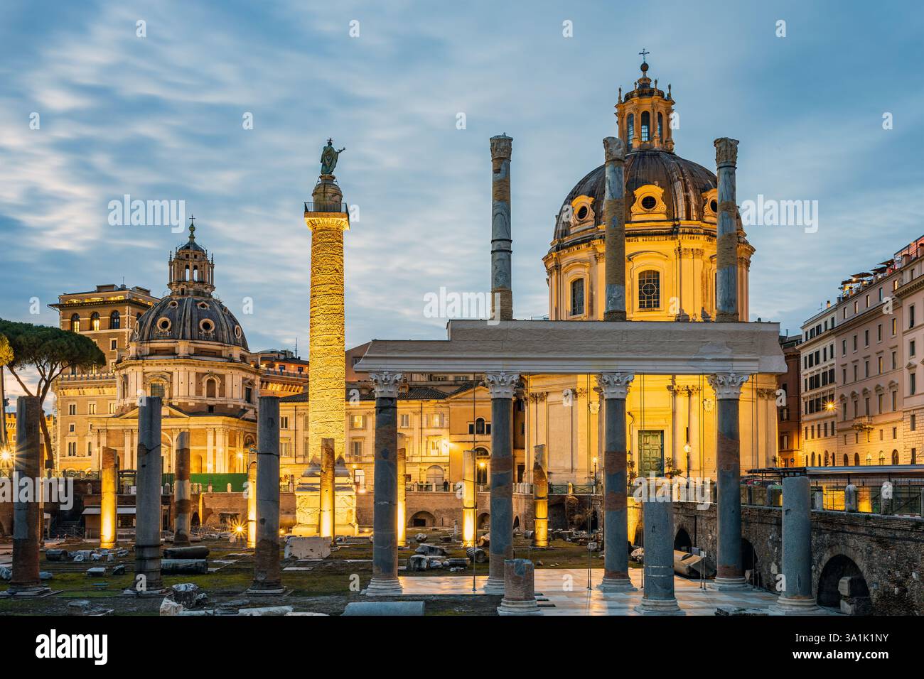 Foro e colonna dell'imperatore Traiano all'ora blu serale. Sullo sfondo si erge la chiesa illuminata di Santa Maria di Loreto. Foto scattata il Foto Stock