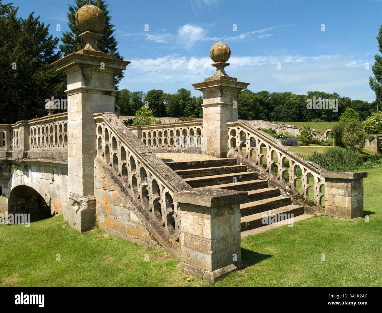 Gradini di pietra, balaustre e pilastri di un ponte ornamentale a Easton Walled Gardens, Grantham, Lincolnshire, Inghilterra, Regno Unito Foto Stock