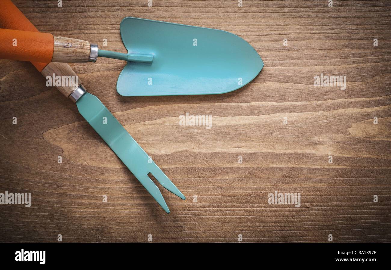 Cazzuola manuale per tosatrice a radice metallica su tavola di legno Foto Stock
