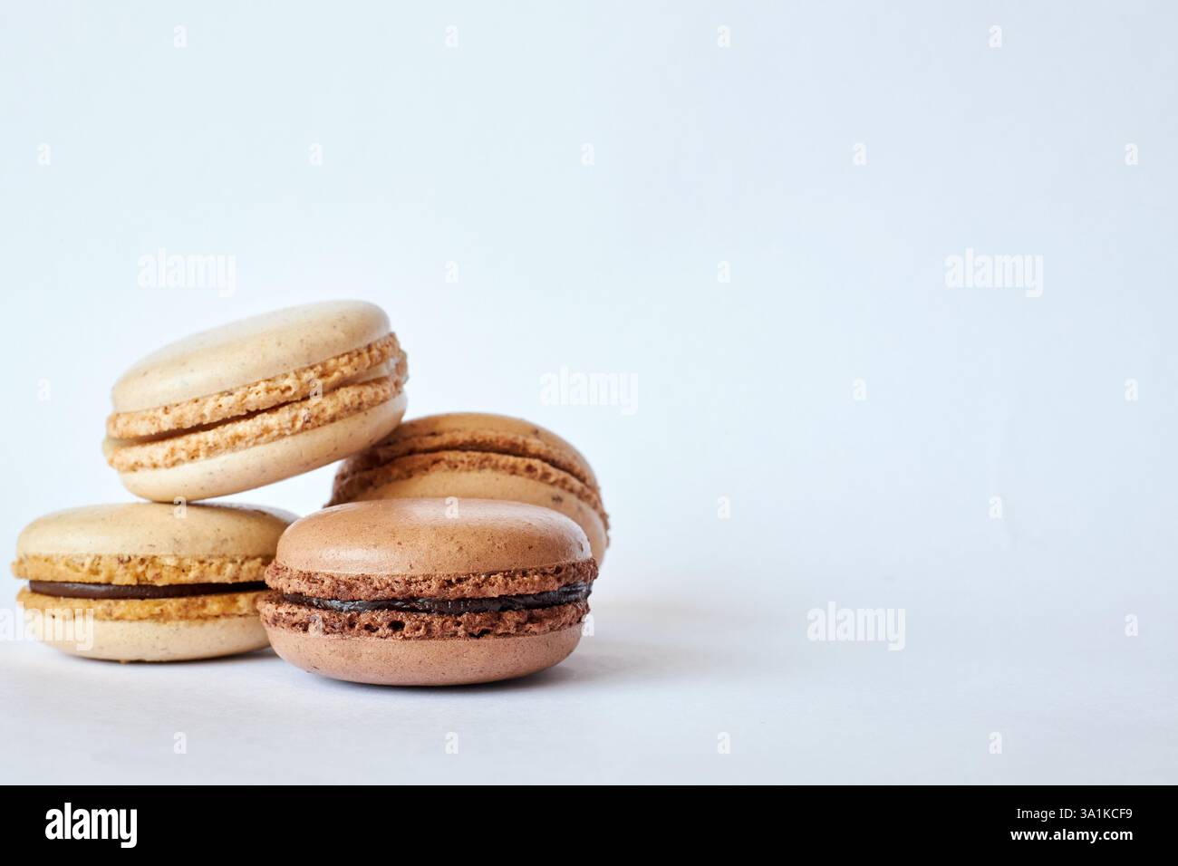 Quattro macaron francesi marroni, torte dai sapori diversi, caffè e creme brulee. Piramide di dessert fatti in casa, macaroon con vista laterale, spazio copie Foto Stock