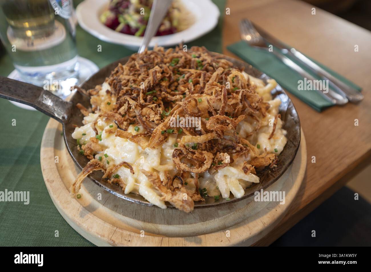 Spaetzle di formaggio con cipolle fritte servito in una piccola padella in una locanda, Franconia, Baviera, Germania, Europa Foto Stock