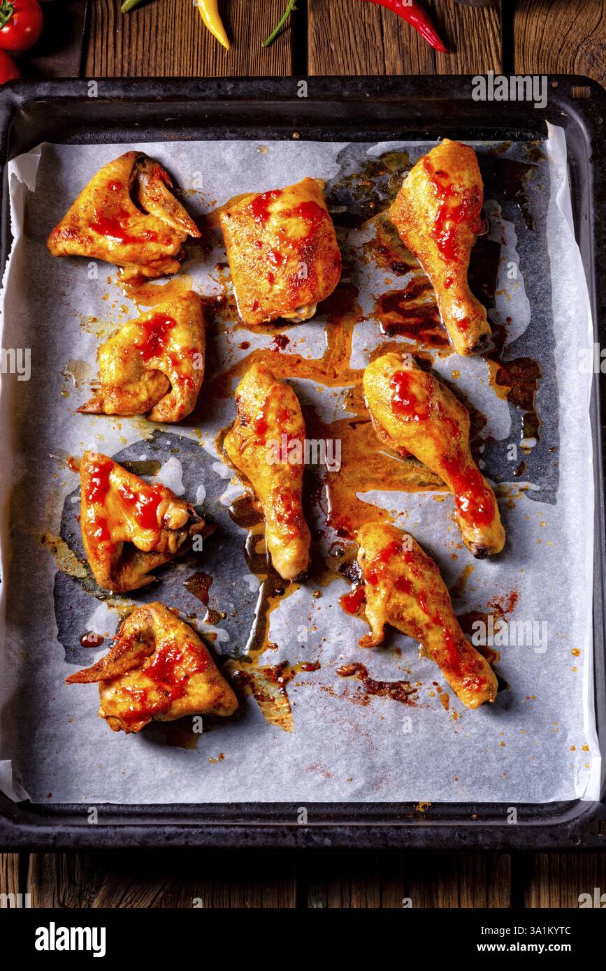 Ali di pollo rustiche e gambe sul vassoio da forno Foto Stock