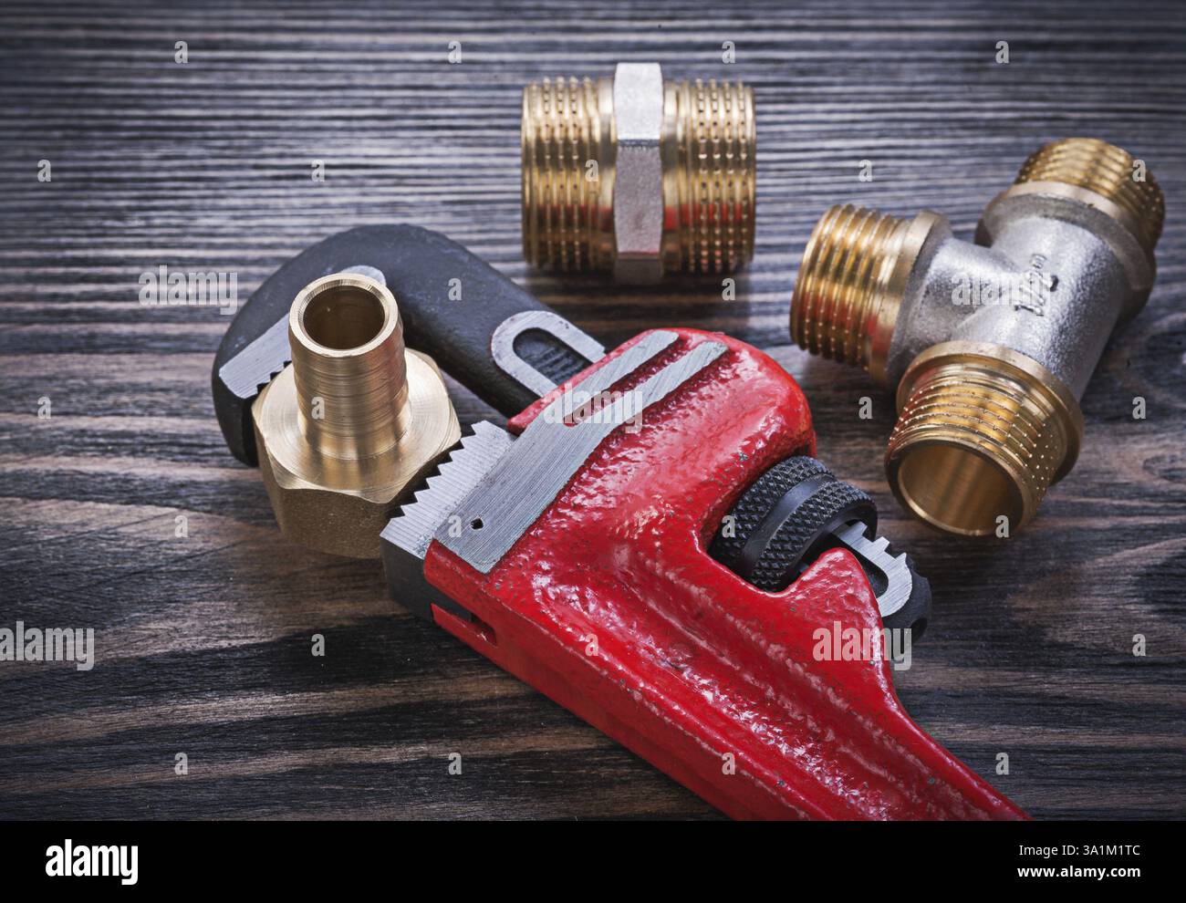 Connettori per tubi flessibili con raccordo a T uguale in ottone per chiave a brugola su pannello di legno Foto Stock